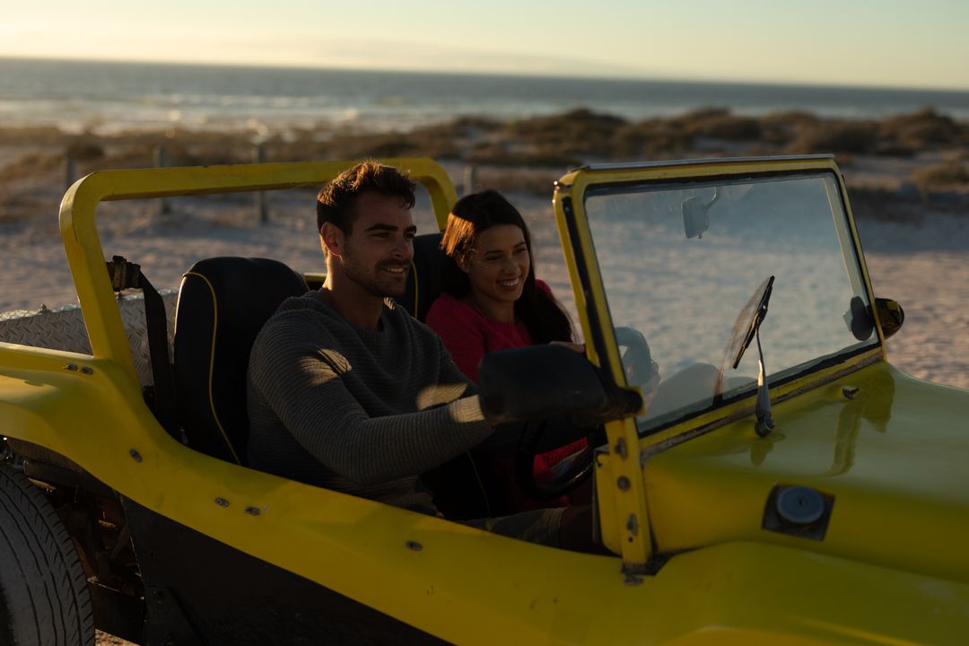 Couple Driving Beach Buggy at Sunset by the Sea - Free Images, Stock Photos and Pictures on Pikwizard.com