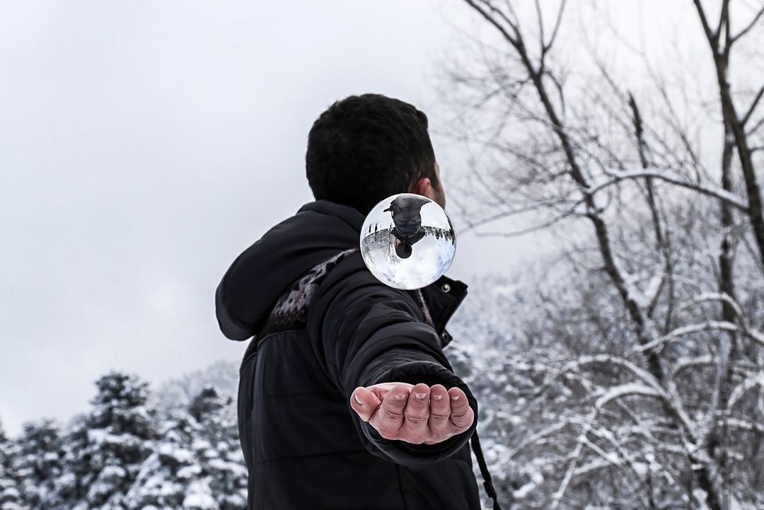 Man Holding Crystal Ball in Snowy Forest - Free Images, Stock Photos and Pictures on Pikwizard.com