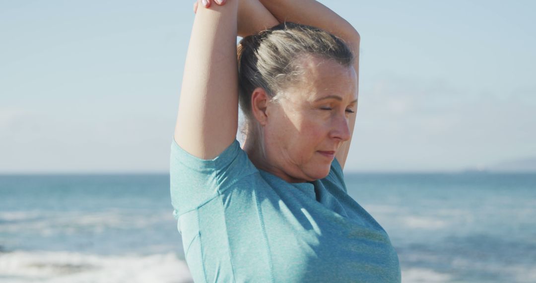 Senior Woman Stretching Outdoors by the Sea - Free Images, Stock Photos and Pictures on Pikwizard.com