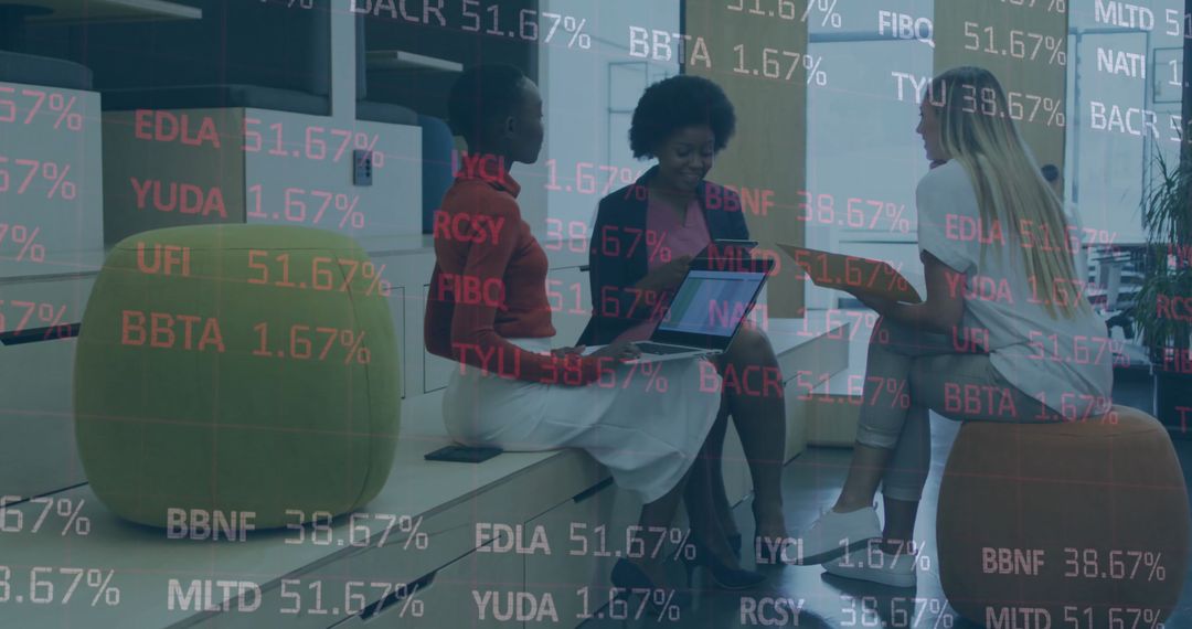 Women in Business Attire Collaborating on Digital Devices with Stock Ticker
