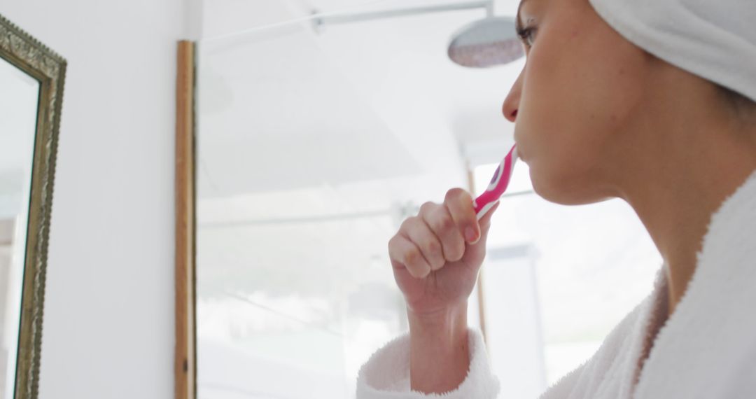 Morning Routine with Woman Brushing Teeth and Looking in Mirror - Free Images, Stock Photos and Pictures on Pikwizard.com