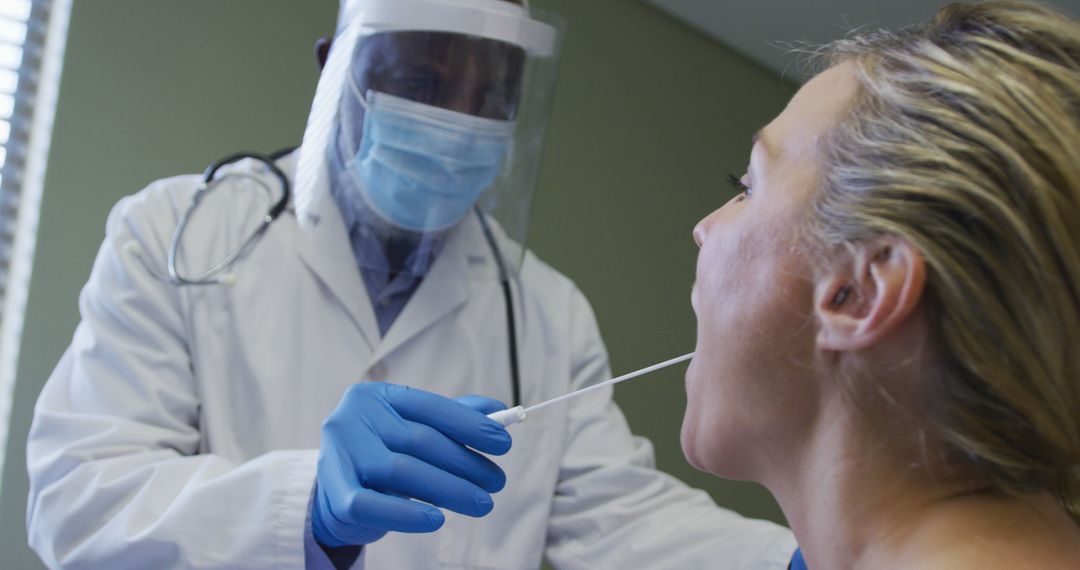 Diverse female patient and doctor wearing face mask doing covid swab test - Free Images, Stock Photos and Pictures on Pikwizard.com