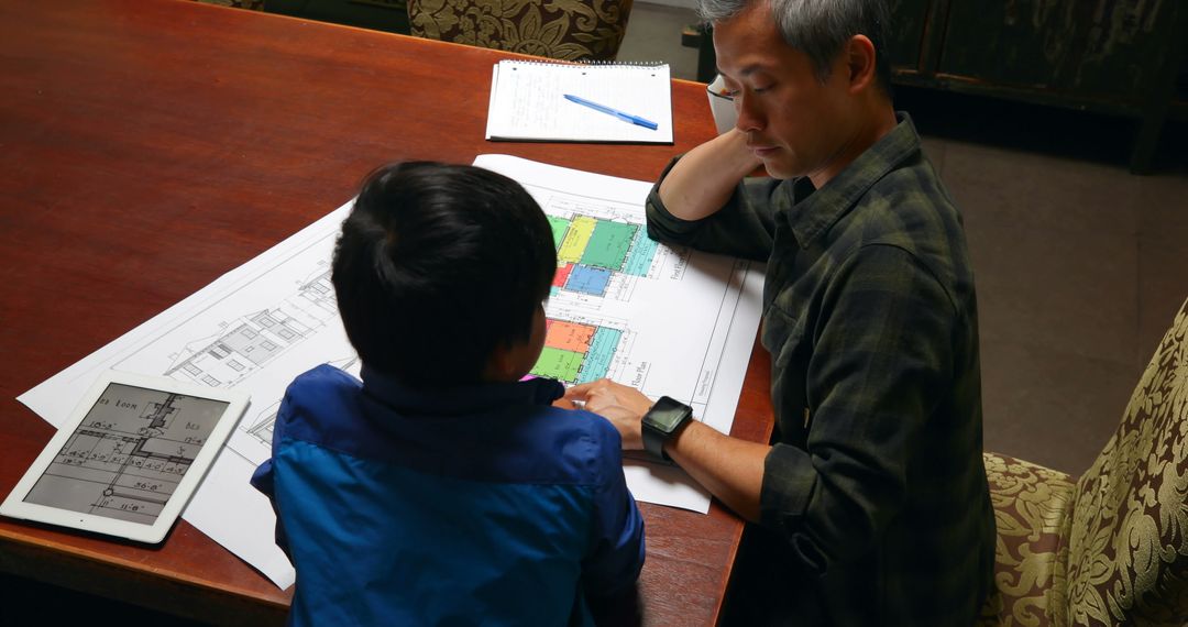 Father and Son Discussing Architectural Plans at Home - Free Images, Stock Photos and Pictures on Pikwizard.com