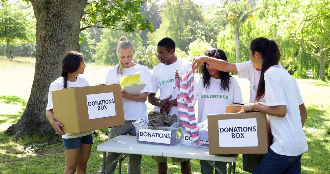 Smiling Volunteers Sorting Donations Outdoors on Sunny Day - Free Images, Stock Photos and Pictures on Pikwizard.com