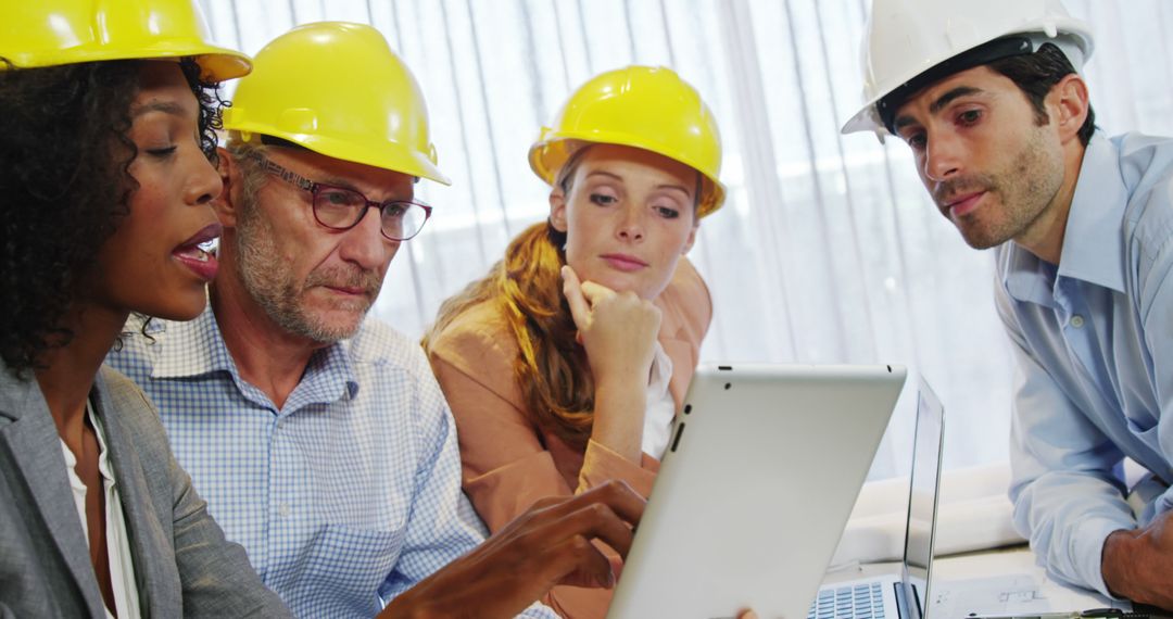 Diverse Team with Hard Hats Discussing Project on Tablet - Free Images, Stock Photos and Pictures on Pikwizard.com