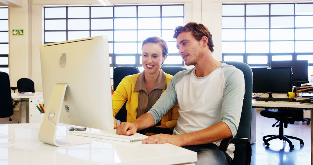 Two Colleagues Collaborating on Desktop Computer in Modern Office - Free Images, Stock Photos and Pictures on Pikwizard.com