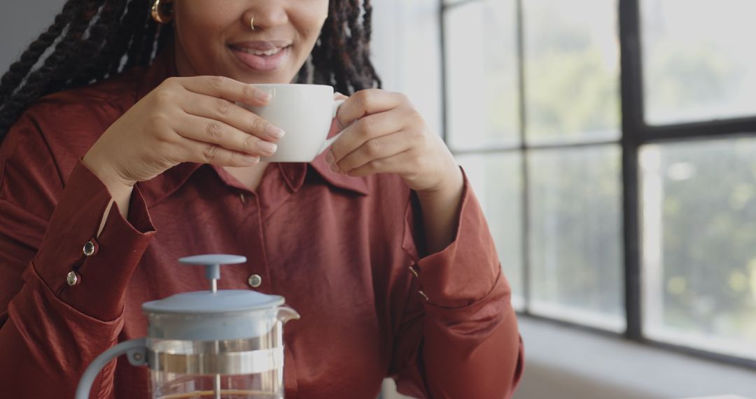 Woman Smiling While Enjoying Coffee At Work