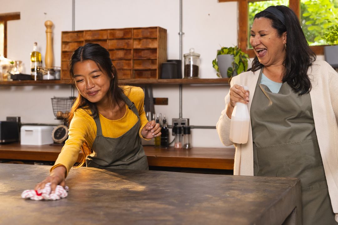 Diverse Female Coworkers Cleaning Stone Countertop in Rustic Kitchen