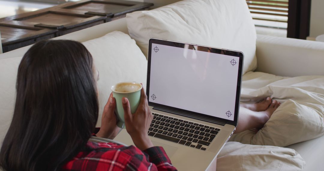 Woman Relaxing on Couch While Using Laptop and Drinking Coffee - Free Images, Stock Photos and Pictures on Pikwizard.com