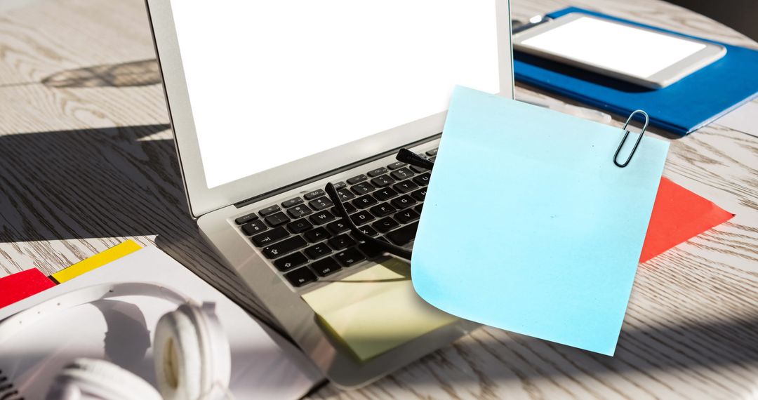 Organized Workspace with Sticky Note on Laptop