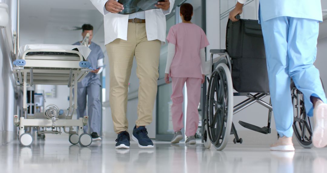 Healthcare Workers Moving Through Hospital Corridor - Free Images, Stock Photos and Pictures on Pikwizard.com