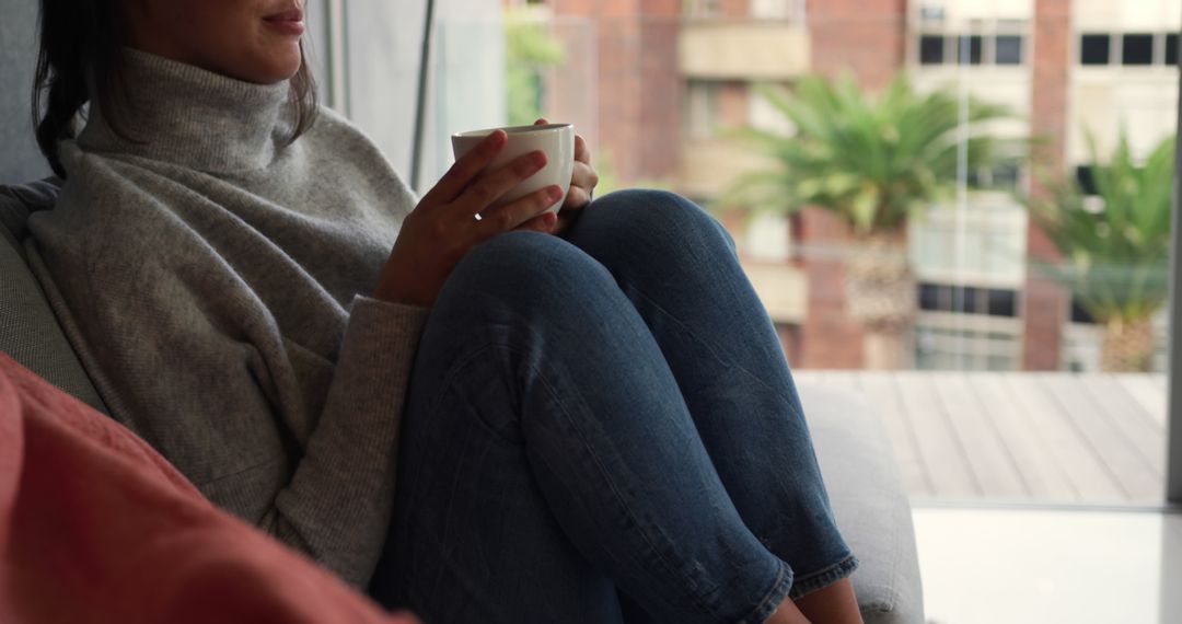 Woman Relaxing with Coffee in Modern Apartment Setting - Free Images, Stock Photos and Pictures on Pikwizard.com