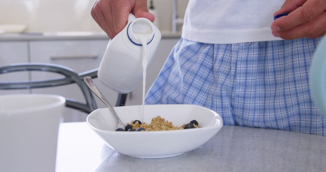 Man Pouring Milk into Bowl of Cereal in Blue Plaid Pajamas - Free Images, Stock Photos and Pictures on Pikwizard.com