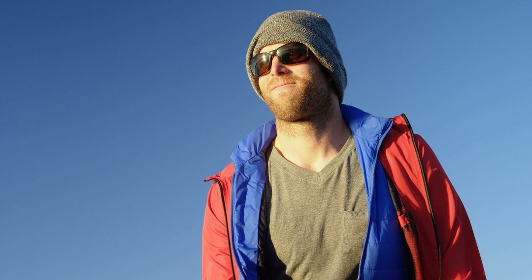 Man Wearing Winter Gear Smiling Outdoors Under Clear Sky - Free Images, Stock Photos and Pictures on Pikwizard.com