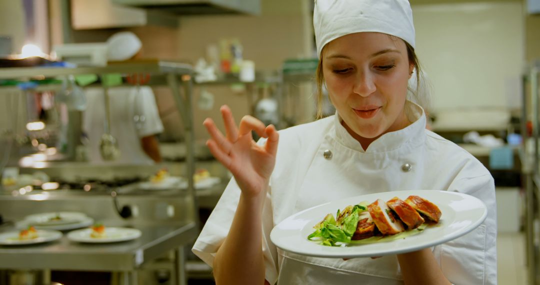 Female Chef Approving Freshly Cooked Gourmet Dish in Restaurant Kitchen - Free Images, Stock Photos and Pictures on Pikwizard.com