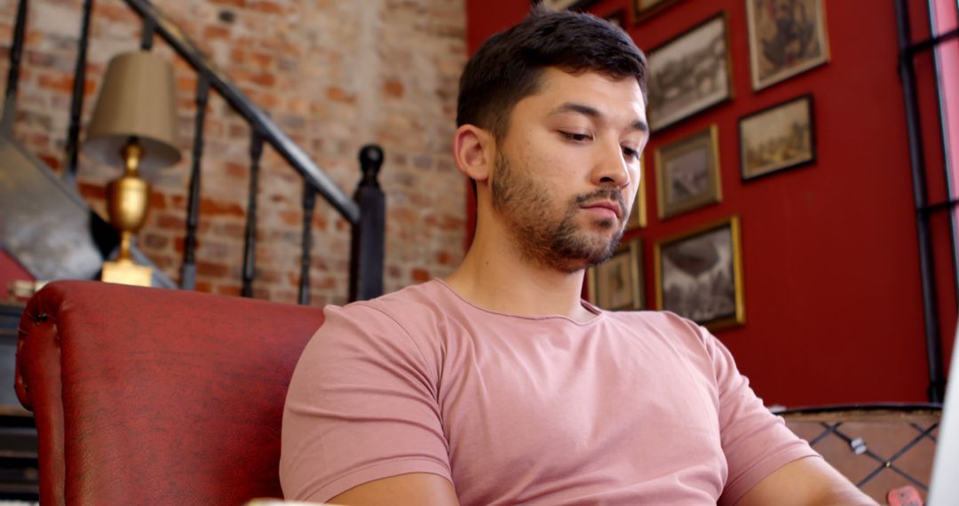 Young Man Relaxing on Red Couch in Art-Filled Room Interior