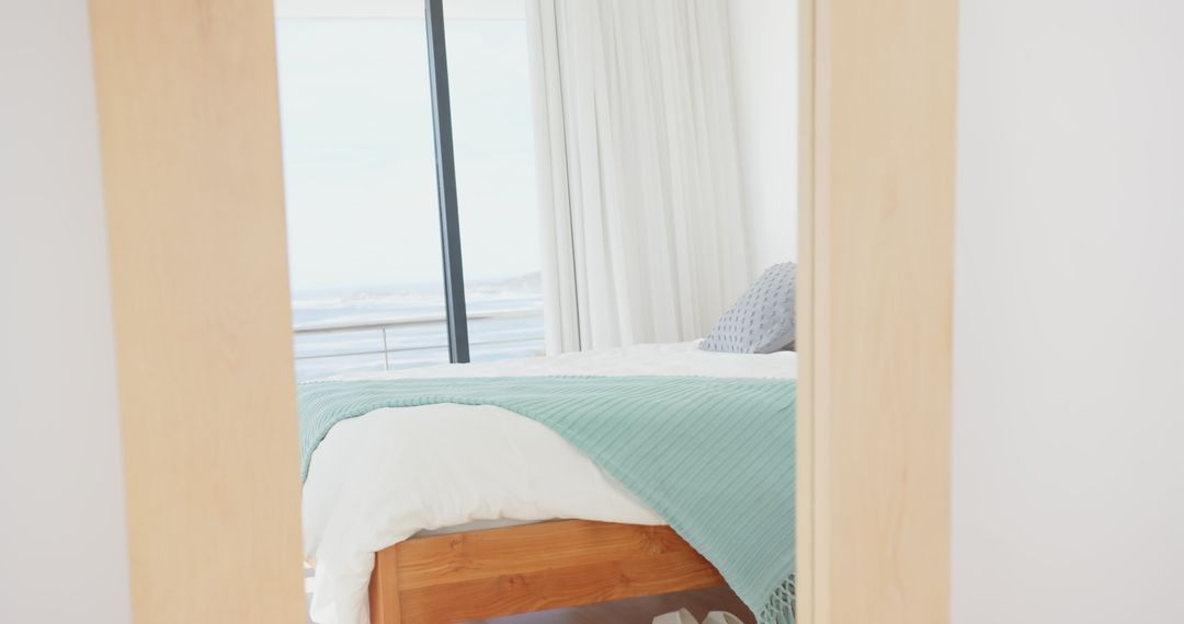 Sunlight in Serene Coastal Bedroom with Ocean View and Wooden Bed
