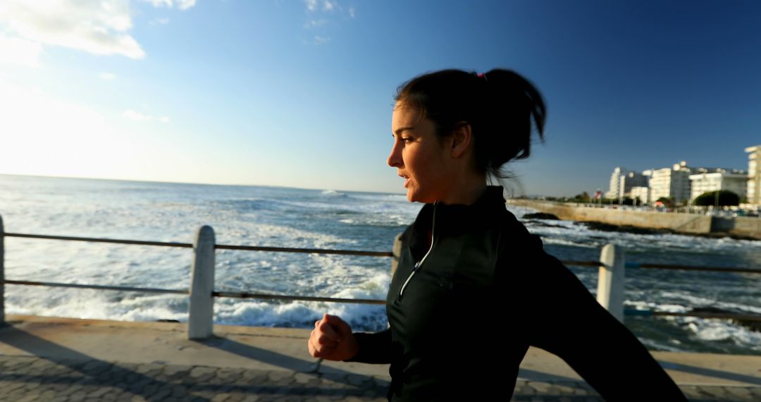 Woman Jogging Along Oceanfront Promenade in Morning - Free Images, Stock Photos and Pictures on Pikwizard.com