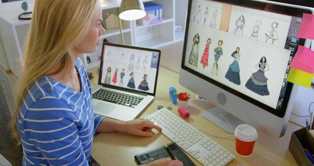 Fashion Designer Working on Computer with Designs