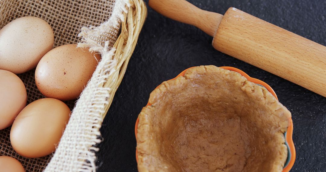 Rustic Baking Scene with Eggs, Rolling Pin, and Dough in Bowl - Free Images, Stock Photos and Pictures on Pikwizard.com