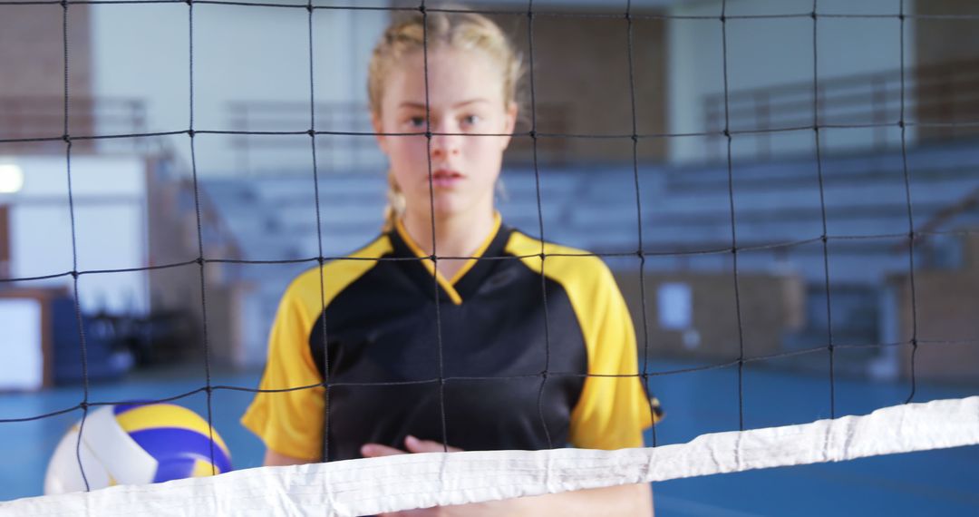 Female Volleyball Player Holding Ball Behind Net in Gym - Free Images, Stock Photos and Pictures on Pikwizard.com