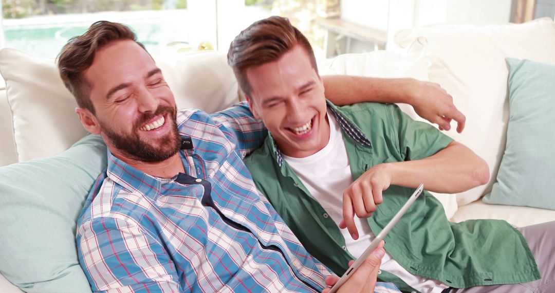 Happy People Laughing On Couch While Using Tablet - Free Images, Stock Photos and Pictures on Pikwizard.com