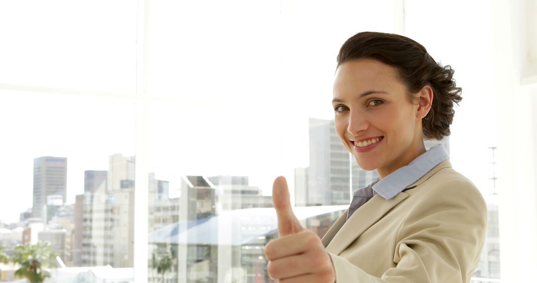 Smiling businesswoman giving thumbs up in the office - Free Images, Stock Photos and Pictures on Pikwizard.com