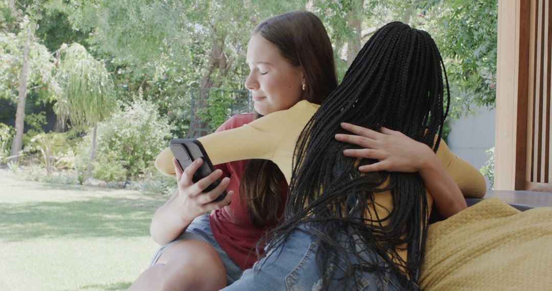 Two Women Hugging Outdoors With Smartphone - Free Images, Stock Photos and Pictures on Pikwizard.com