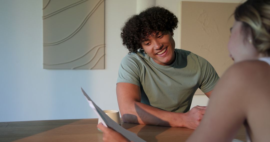Young Man Using Tablet with Coffee Mug on Table