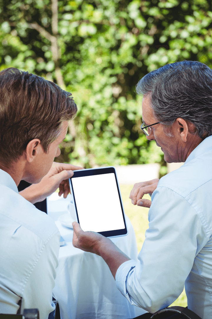 Two Professionals Discussing Business on Tablet with Transparent Screen