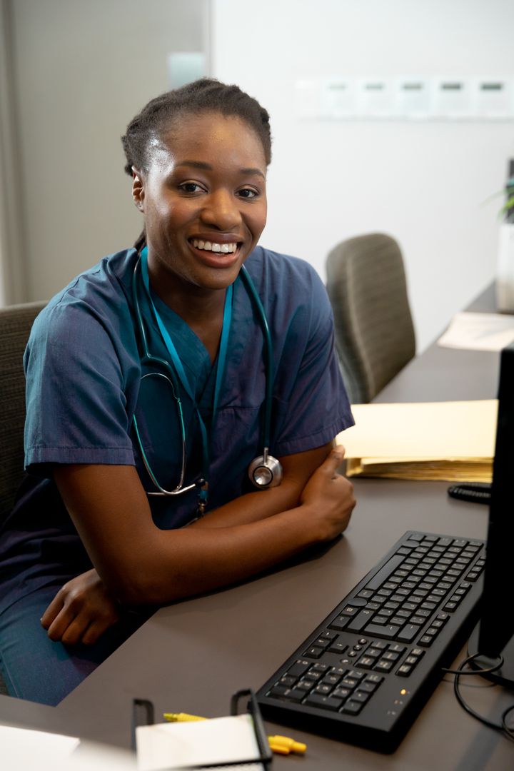 Smiling African American Female Doctor at Desk with Computer - Free Images, Stock Photos and Pictures on Pikwizard.com