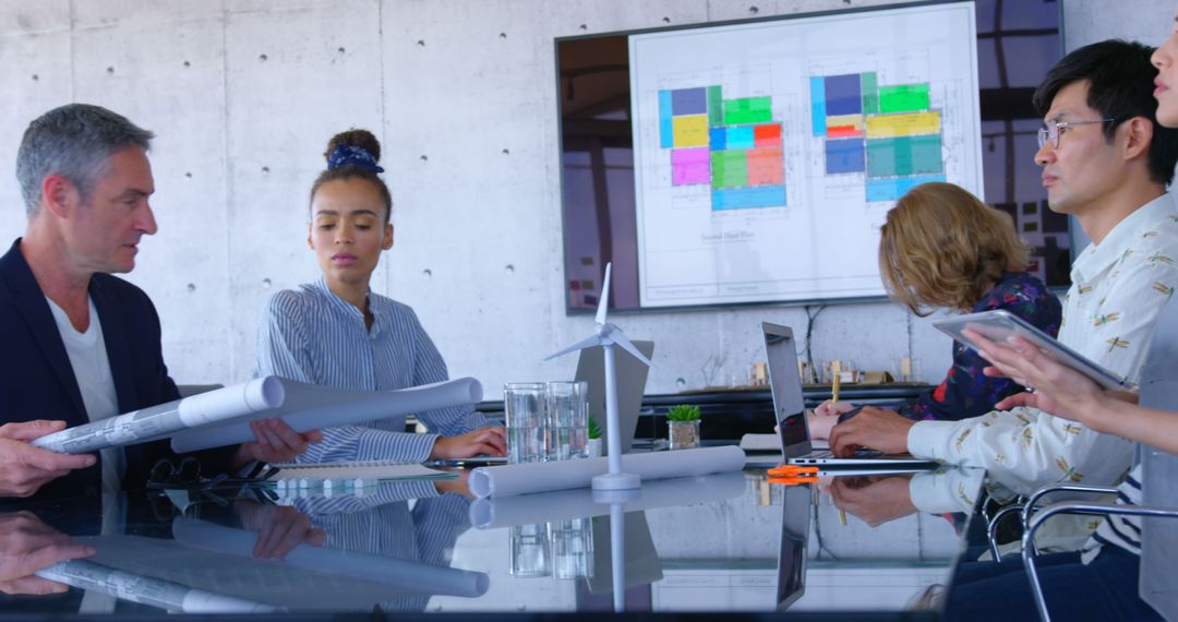 Diverse Professionals Analyzing Blueprint in Conference Room