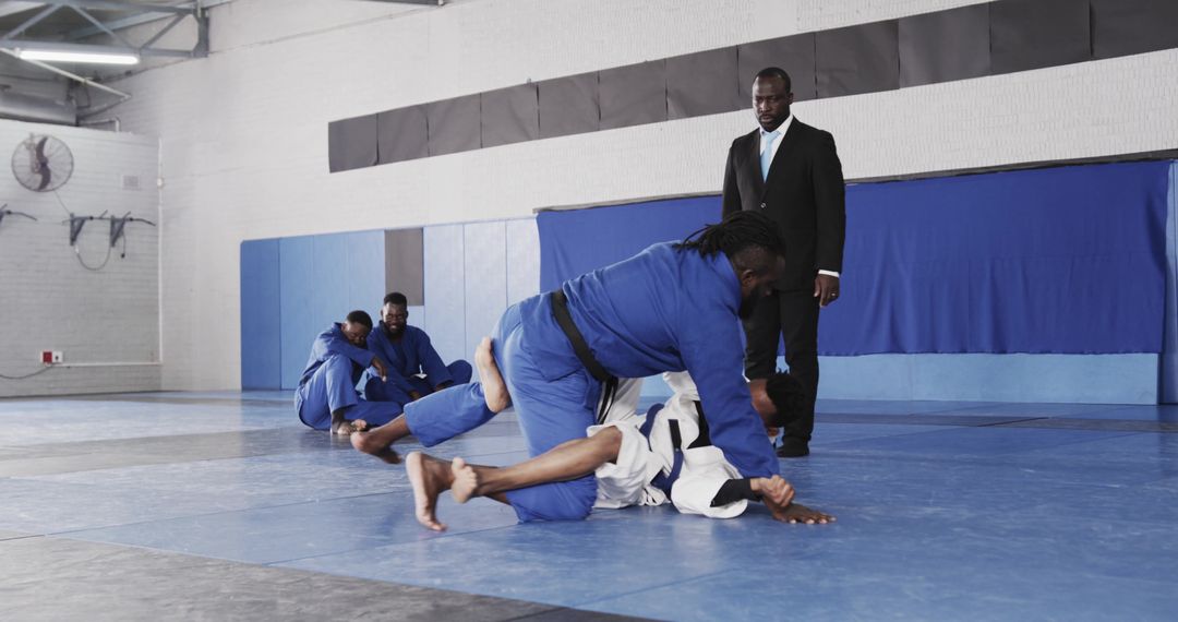 African American Men Training Brazilian JiuJitsu in Dojo