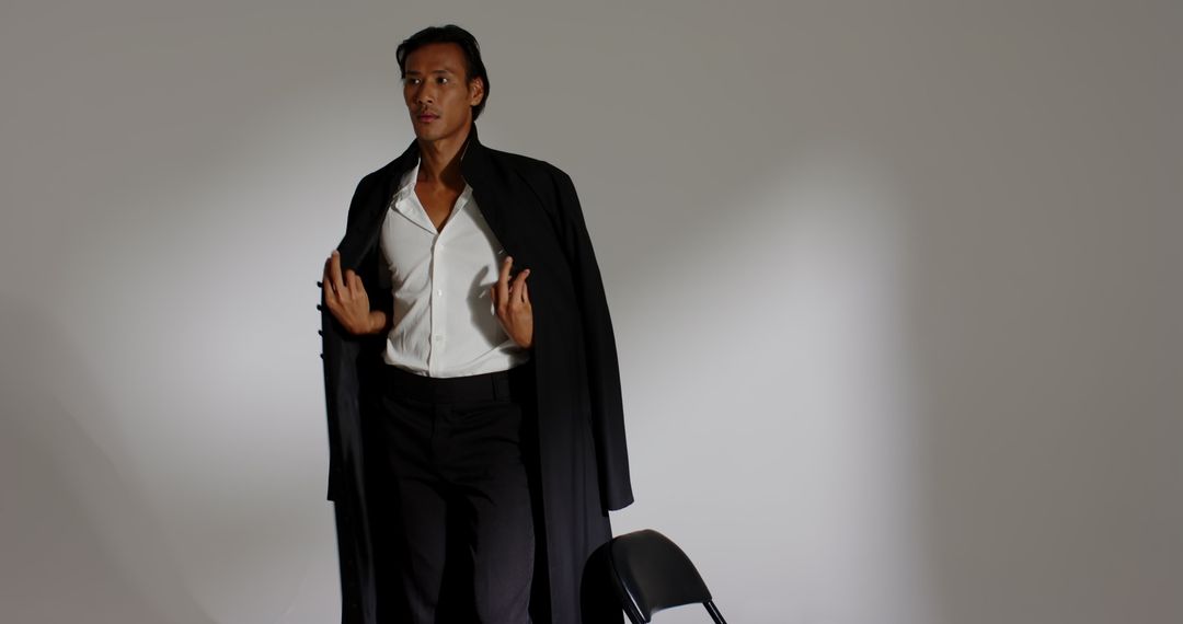 Elegant Man in Black Overcoat in Studio Setting