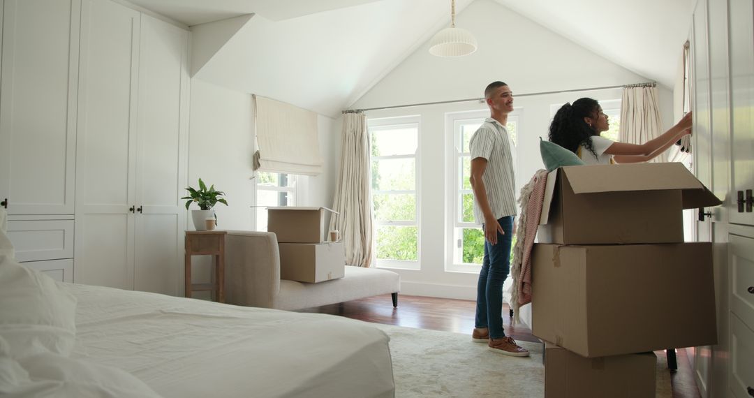 Couple Sorting Belongings in New Home with Moving Boxes Around
