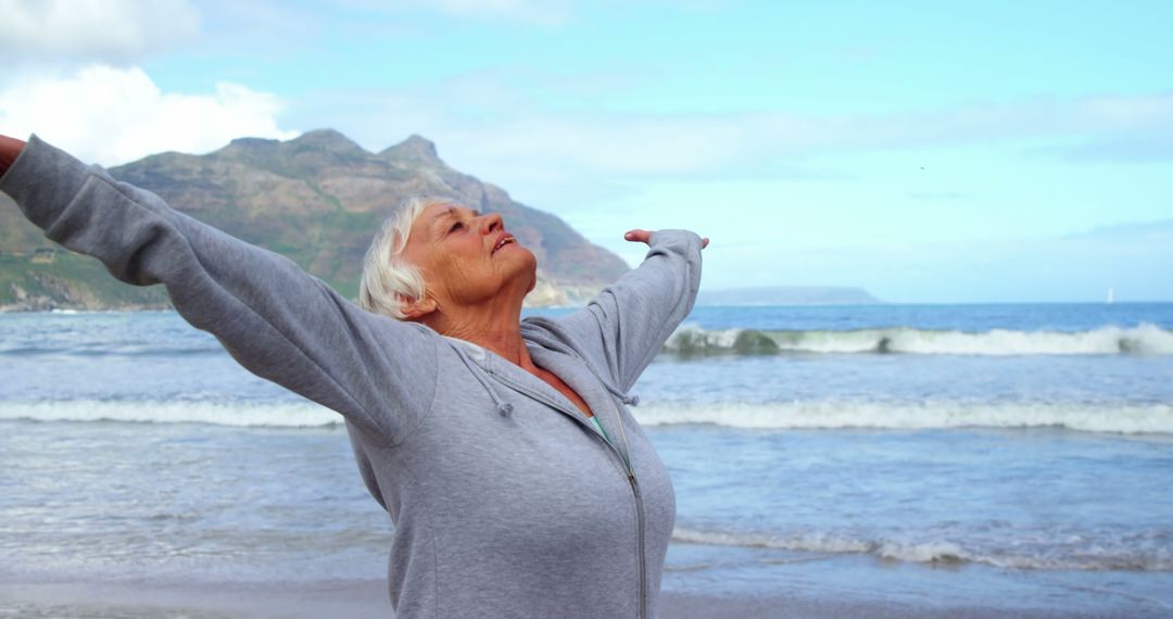 Senior Woman Embracing Freedom at Beach with Open Arms - Free Images, Stock Photos and Pictures on Pikwizard.com