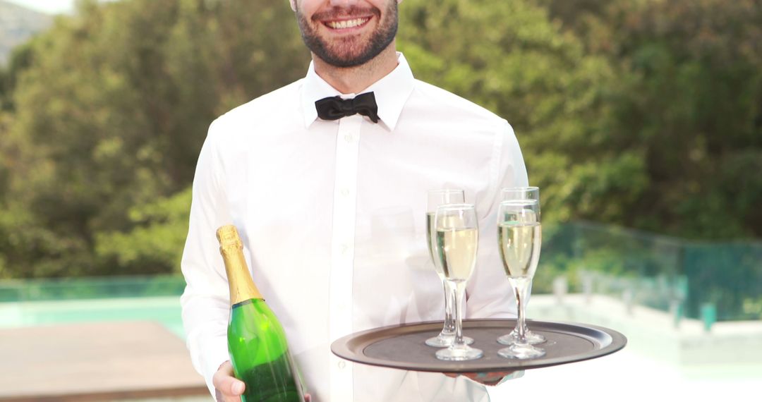 A professional waiter serves champagne outdoors, indicating a high-end event. - Free Images, Stock Photos and Pictures on Pikwizard.com