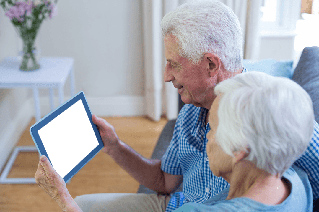 Senior Couple Relaxing with Transparent Tablet at Home Interior