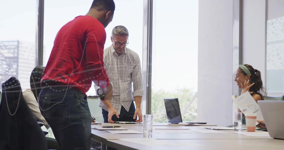 Business Team Collaborating with Laptops and Charts in Modern Office