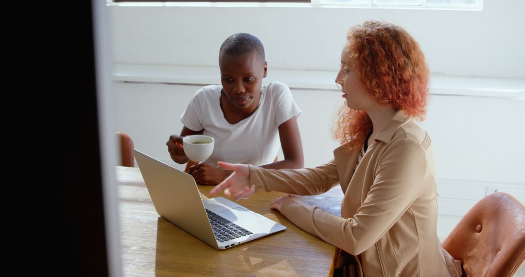 Diverse Team Collaborating Sev footageully With Coffee and Laptop