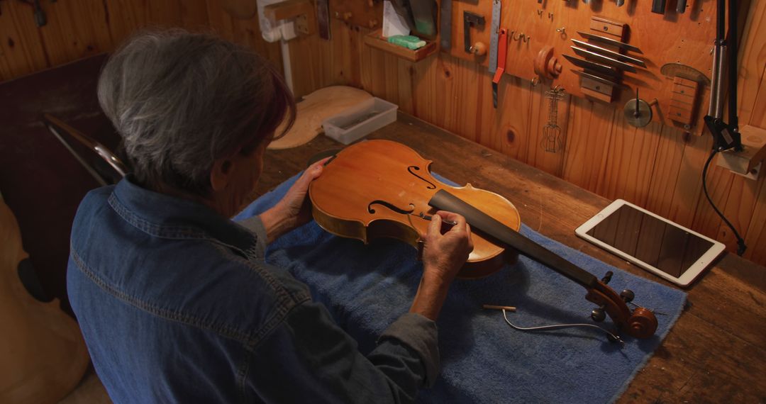 Craftsman Working Attentively on Polishing Wooden Violin in Workshop - Free Images, Stock Photos and Pictures on Pikwizard.com