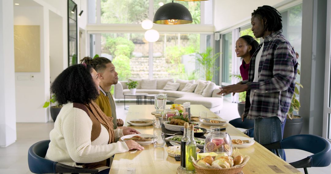 Diverse friends sharing meal and conversation at modern open-plan dining table