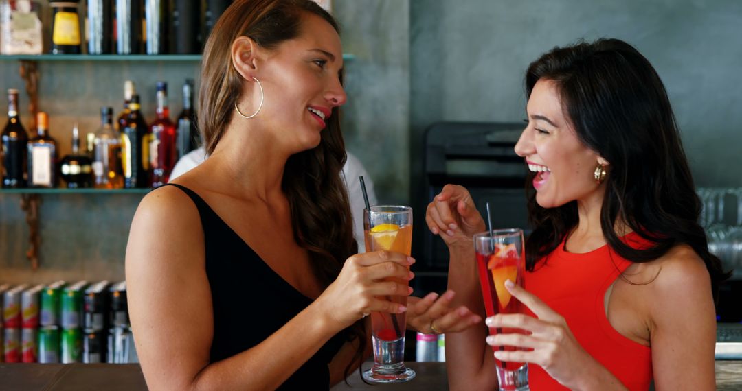 Two Women Enjoying Beverages at Modern Bar with Smiles - Free Images, Stock Photos and Pictures on Pikwizard.com