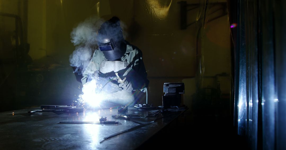 Welder in Protective Gear Welding Metal in Dark Workshop with Sparks - Free Images, Stock Photos and Pictures on Pikwizard.com