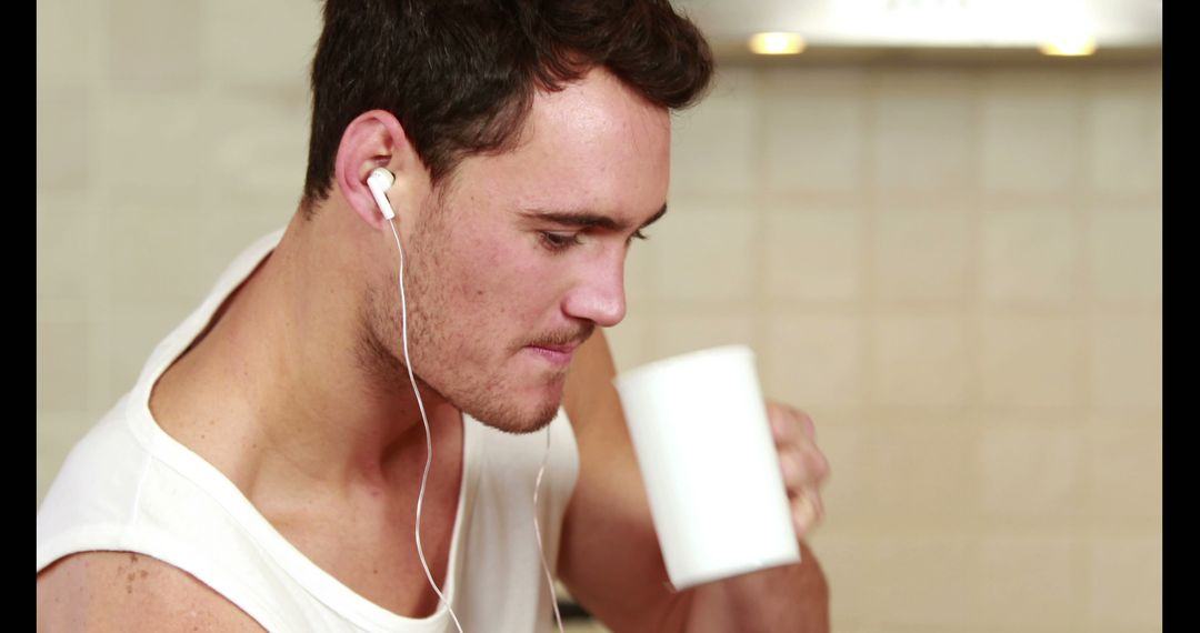 Young Man Drinking Coffee and Listening to Music with Earphones - Free Images, Stock Photos and Pictures on Pikwizard.com