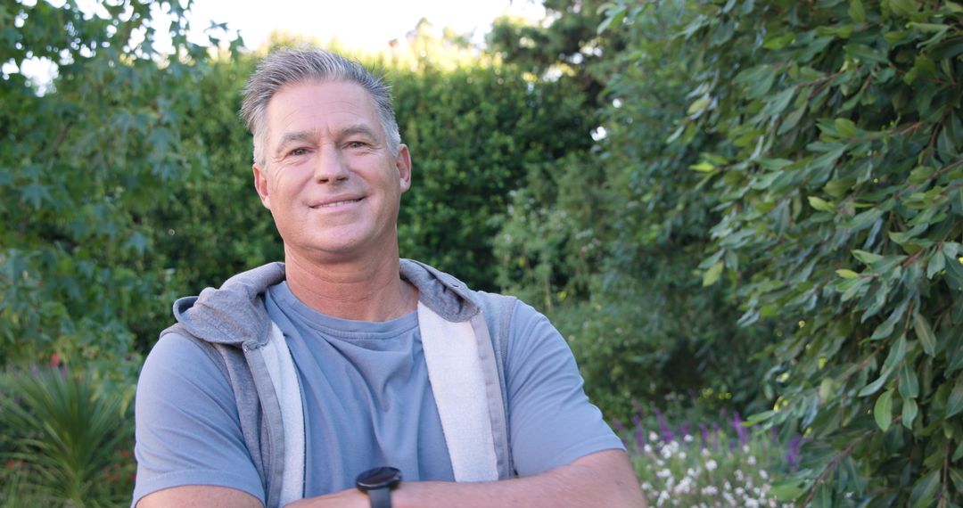 Man Standing in Lush Garden Leisurely Sporting Smartwatch