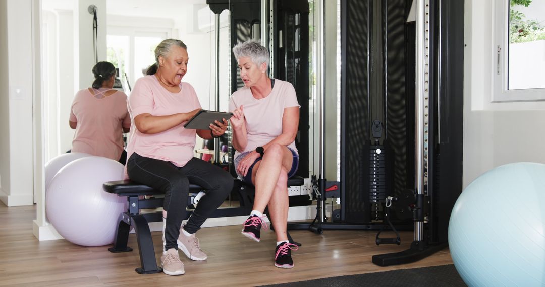 Senior Couple Discussing Fitness Goals via Tablet in Home Gym