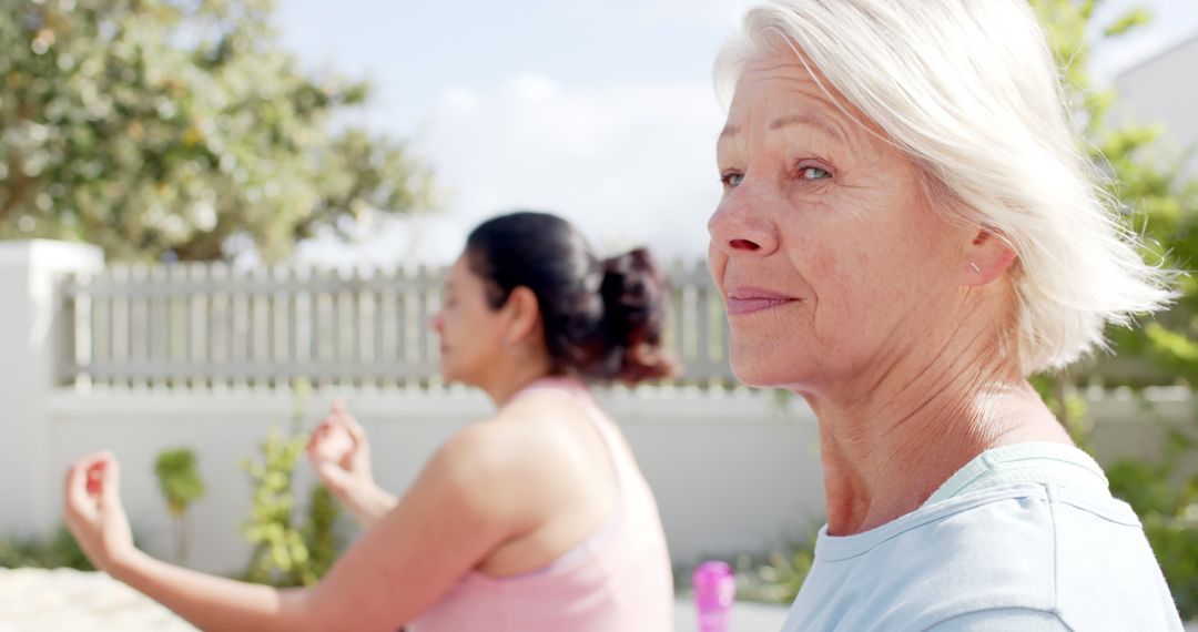 Senior Women Enjoying Outdoor Yoga in Sunlit Garden - Free Images, Stock Photos and Pictures on Pikwizard.com