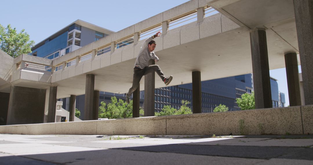 Urban Freerunner Jumping Over Concrete Structure in Cityscape - Free Images, Stock Photos and Pictures on Pikwizard.com