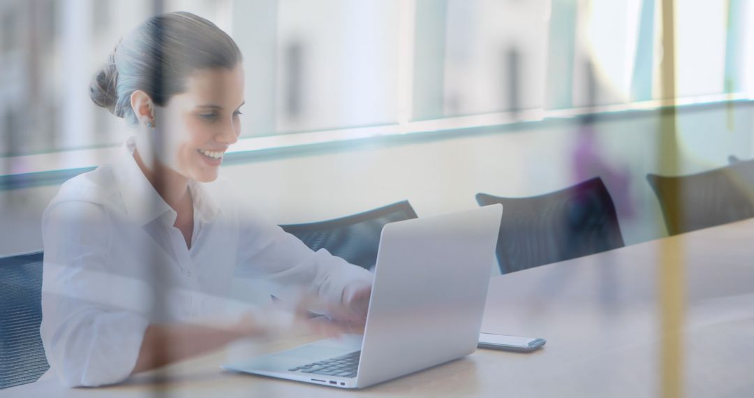 Smiling Businesswoman Working on Laptop at Modern Office Table